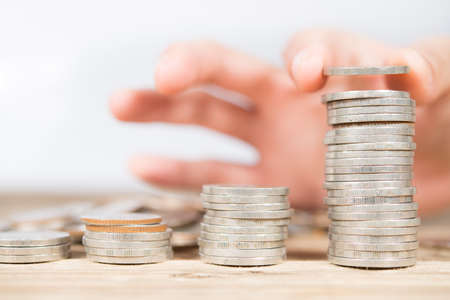 Hand stacking up Thai coins. Abstract of money growing or saving.