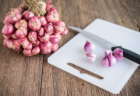 Red onions on a plastic chopping boardの写真素材