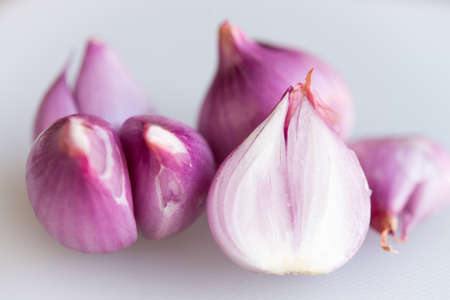 Red onions on a plastic chopping boardの写真素材