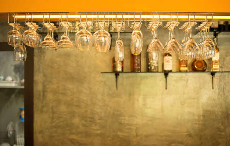 Empty glasses for wine above a bar rackの写真素材