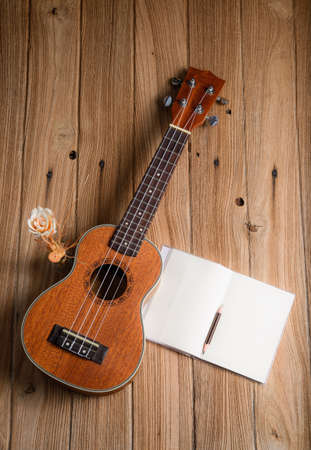 ukulele with notebook on wood backgroundの写真素材