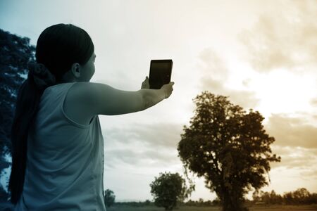 Woman using digital tablet PC for take a picture in the parkの写真素材