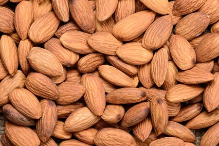 Pile of almonds close-up as background.