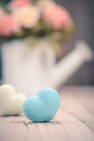 macarons in heart shape with flower on wood table,vintage tone styleの写真素材