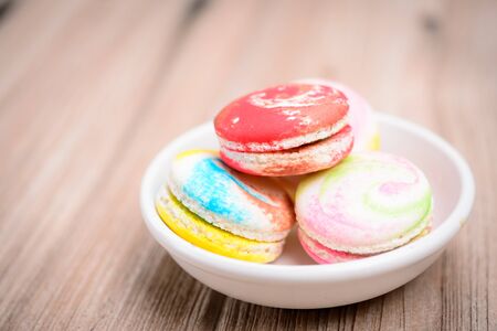 A lot of french colorful macarons The plate on wood backgroundの写真素材