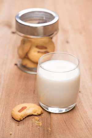cup of milk wite cookies on wood tableの写真素材