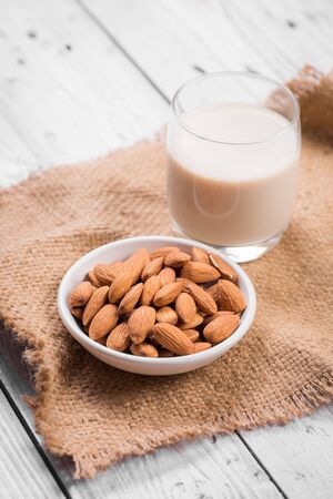 Almond milk in glass with almondsの写真素材