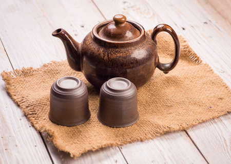 Teapot and two cups of tea on wood tableの写真素材