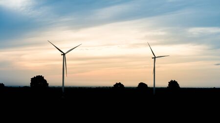 beautiful landscape image with Windturbine at the sunriseの写真素材