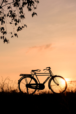 beautiful landscape image with Bicycle at sunsetの写真素材