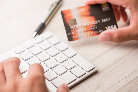 hand holding a credit card and typing. On-line shopping on the internetの写真素材