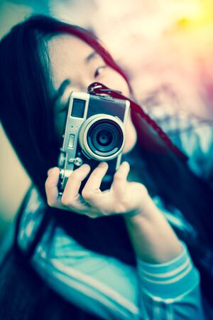 beautiful woman with classic camera in hand ; vintage filter effectの写真素材
