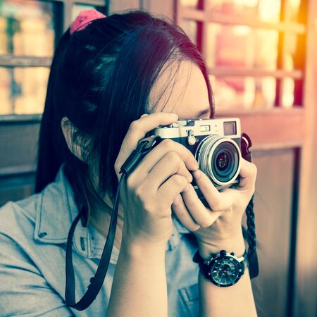 beautiful woman with classic camera in hand ; vintage filter effectの写真素材