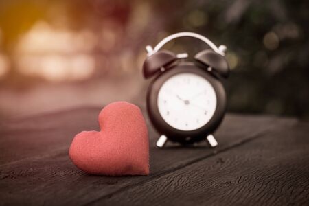 Vintage background with retro alarm clock on table , vintage filter effectの写真素材