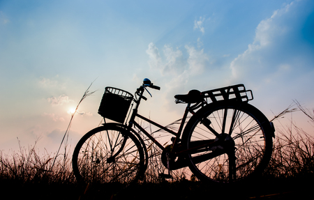 beautiful landscape image with Silhouette Bicycle at sunset in vintage tone styleの写真素材