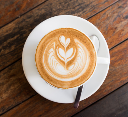 A Cup of hot latte art coffee on wooden tableの写真素材