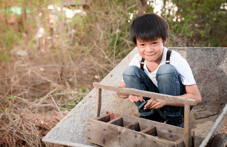 Cute Asian boy sit on a cartの写真素材