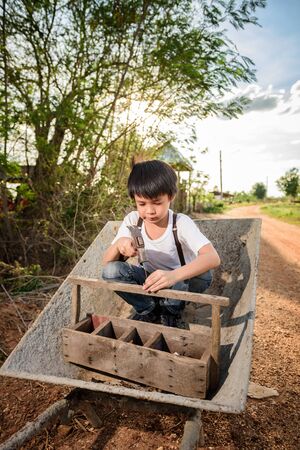 Cute Asian boy playing on a cartの写真素材