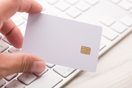 hand holding a white credit card and typing. On-line shopping on the internetの写真素材