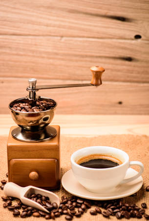 Antique Coffee Grinders with coffee beans and coffee cup in studio shortの写真素材