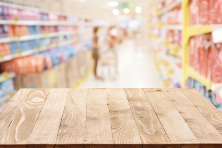 Empty wood table top (or shelf) on Blurred shopping mall background - can montage or display your productsの写真素材