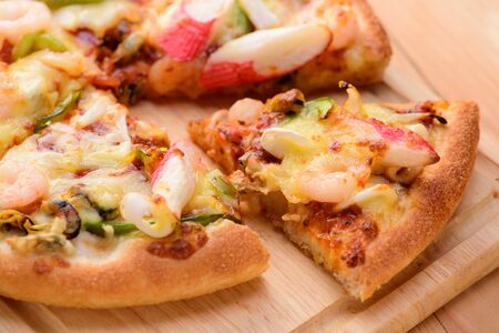 Seafood Italian Pizza slice on wood backgroundの写真素材