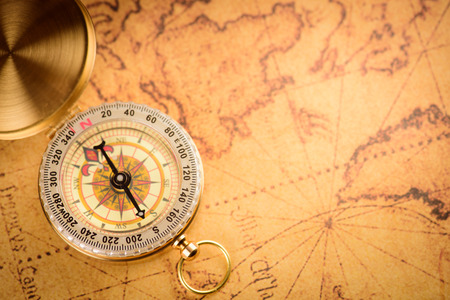 Old  gold vintage compass on vintage map:Heading southの写真素材