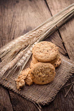 Chocolate cookies on white linen napkin on wooden table. Chocolate chip cookies shot on sackの写真素材