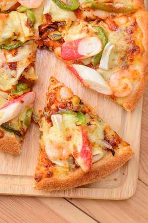 Seafood Italian Pizza slice on wood backgroundの写真素材