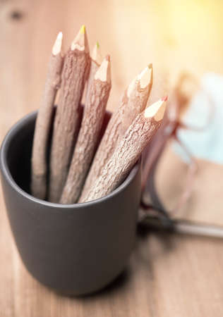 color pencil made of branches in cup with glasses and note book on wood background;vintage filterの写真素材