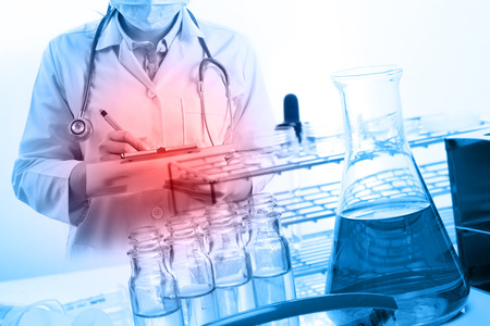scientist writing report with equipment and science experimentsの写真素材