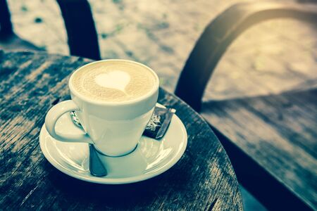 A Cup of hot latte art coffee with heart  Shape on wooden tableの写真素材