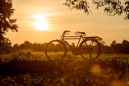 beautiful landscape image with Bicycle at sunsetの写真素材