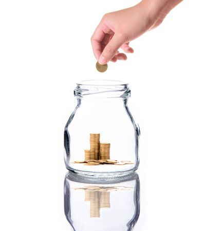 Investment growth concept,Golden coins in clear jar over white background,saving money with woman handの写真素材