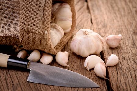 garlic with sack on wood backgroundの写真素材