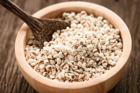organic millet in a wood bowl on wooden rustic table