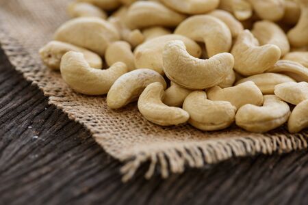 close up of raw cashew nuts on wooden tableの写真素材