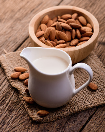 Almond milk in glass with almondsの写真素材