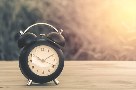 vintage alarm clock on table with blur background and sunray.for greeting Cards ,post cardの写真素材