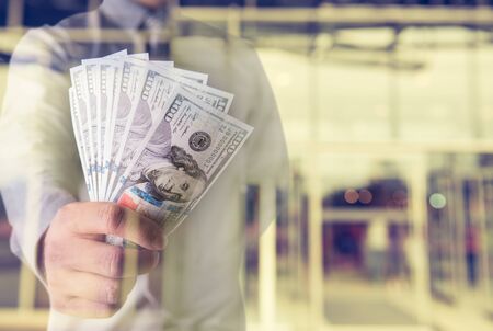 Businessman with money in hand, US dollar (USD) bills - investment, success and profitable business conceptsの写真素材