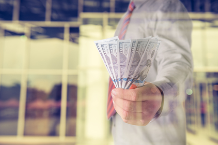 Businessman with money in hand, US dollar (USD) bills - investment, success and profitable business conceptsの写真素材