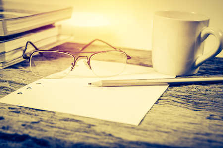 Coffee Cup and office supplies on old wood table.vintage process styleの写真素材