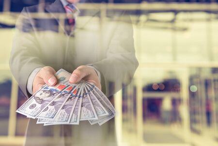 Businessman with money in hand, US dollar (USD) bills - investment, success and profitable business conceptsの写真素材
