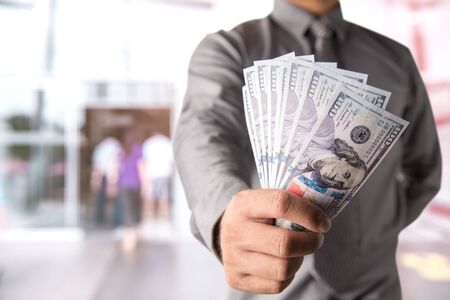 Businessman with money in hand, US dollar (USD) bills - investment, success and profitable business...