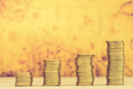Business Finance and Money concept, Money Gold coin stack growing graph with old map backgroundの写真素材