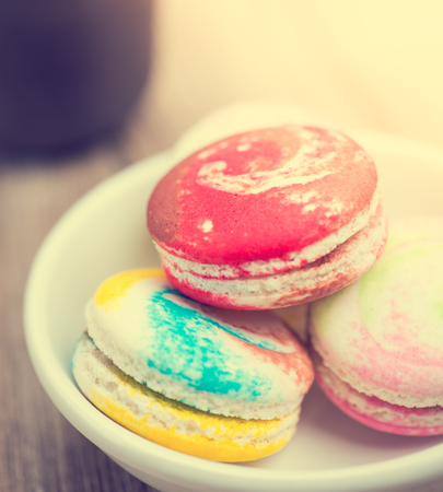 A lot of french colorful macarons The plate on wood backgroundの写真素材