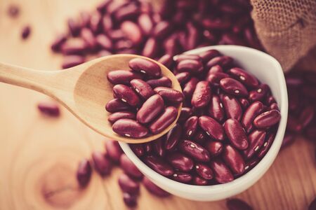 Red Kidney bean in white ceramic bowl and wooden spoonの写真素材
