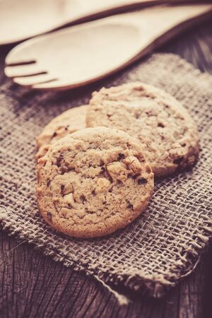 Chocolate cookies on white linen napkin on wooden table. Chocolate chip cookies shot on sackの写真素材