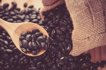 Vigna mungo or black beans in wooden spoonの写真素材