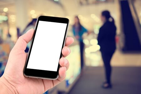 hand holding the phone tablet on blurred in shop counter service background;Transactions by smartphone conceptの写真素材